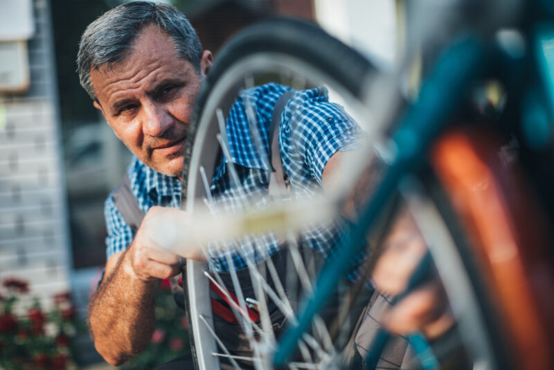 Mature man fixing bike
